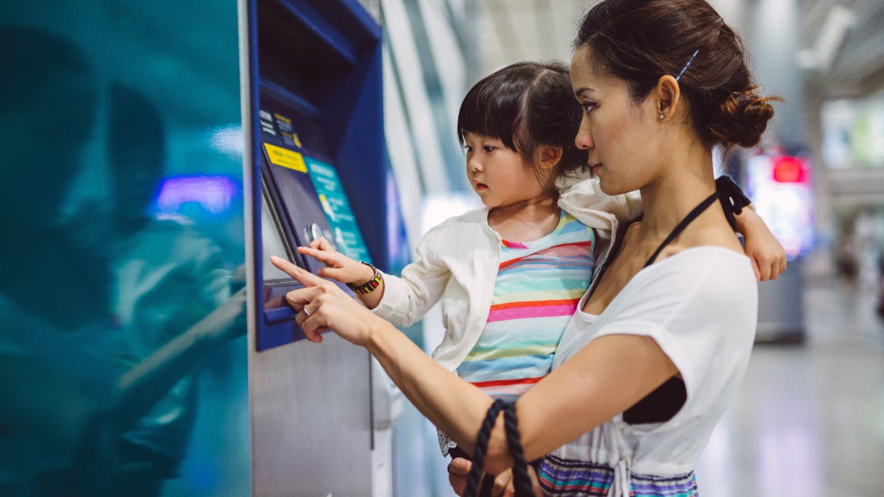 mother at bitcoin atm with toddler