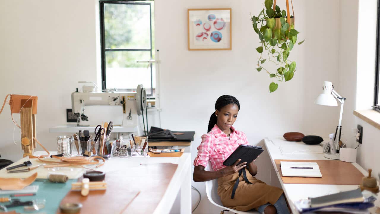 Female, Black small business owner working in her leatherwork studio