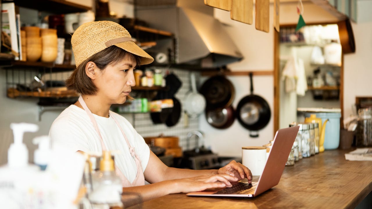 Restaurant owner making purchases on laptop