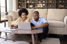 Couple sit in living room discuss receipts, control family budget, calculate household bills to pay