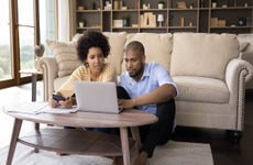 Couple sit in living room discuss receipts, control family budget, calculate household bills to pay