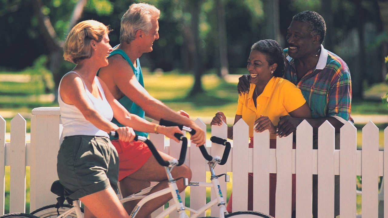 Senior couple on bikes talking to neighbors