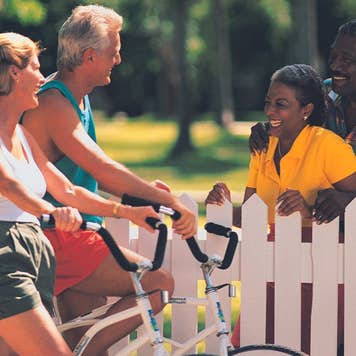 Senior couple on bikes talking to neighbors