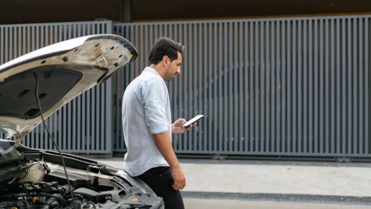 Man calling his car insurance after having a vehicle breakdown on the road
