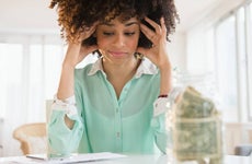 Stressed mixed race woman paying bills