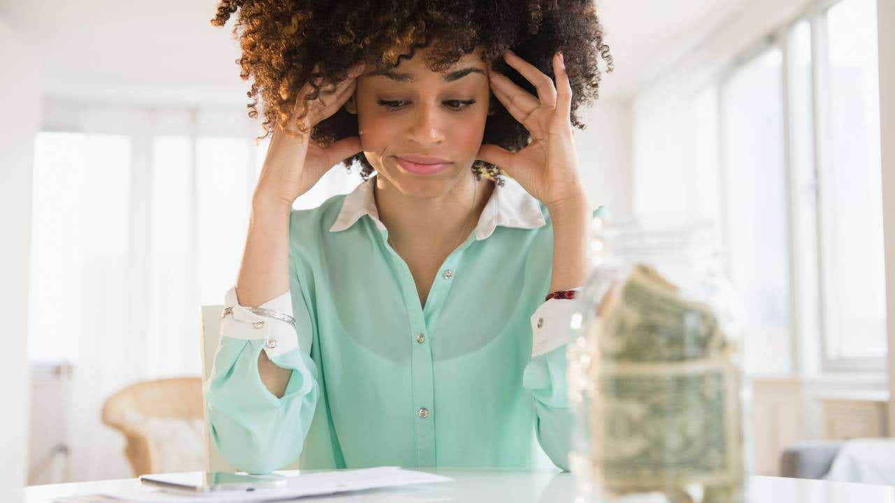Stressed mixed race woman paying bills