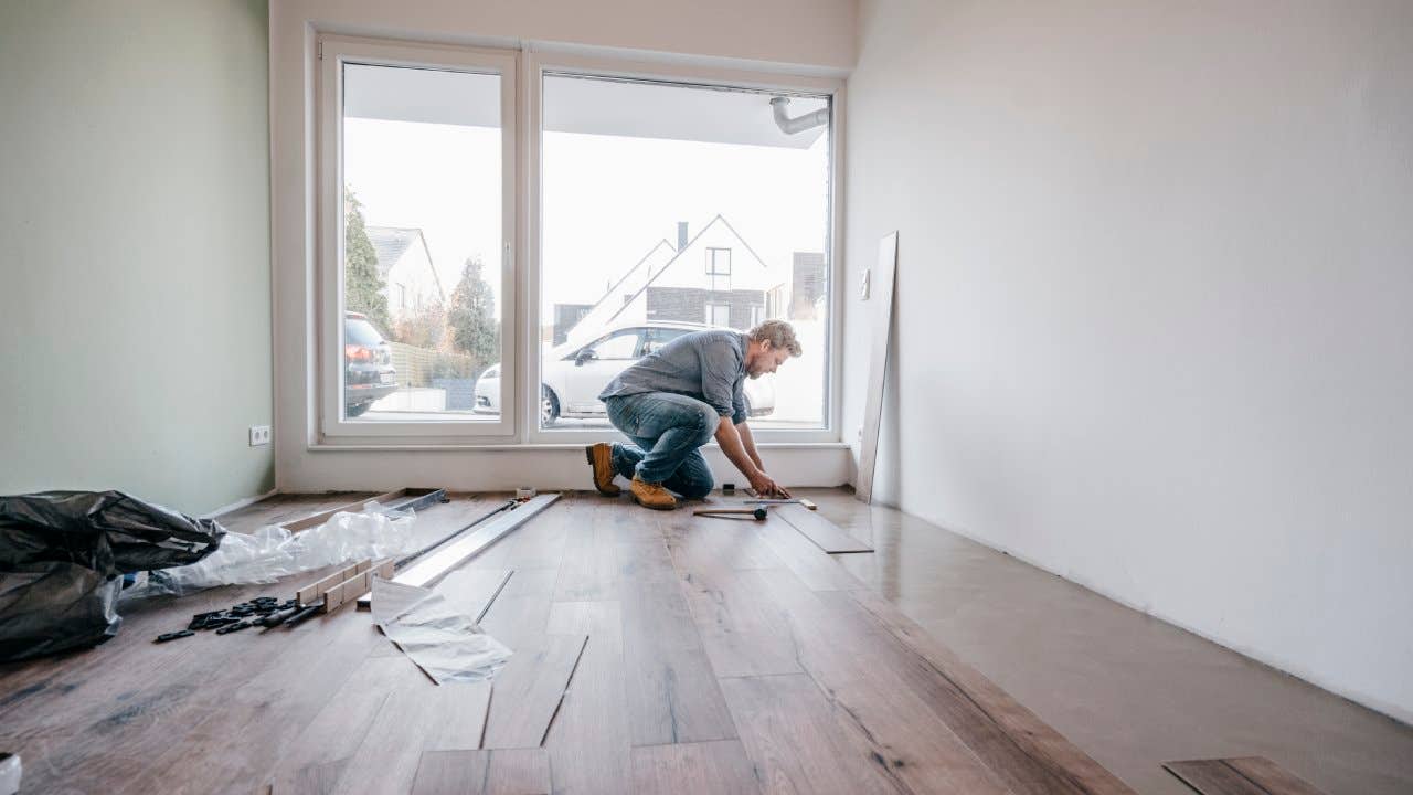 Man fitting flooring in a home