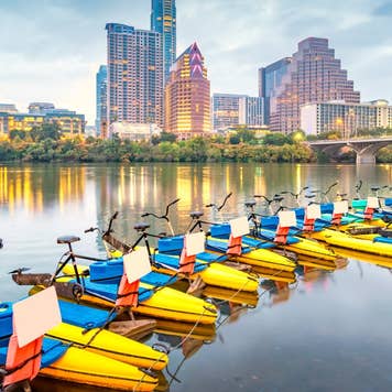 Water Bikes in the Colorado River and the skyline of Austin, Texas, USA at night.