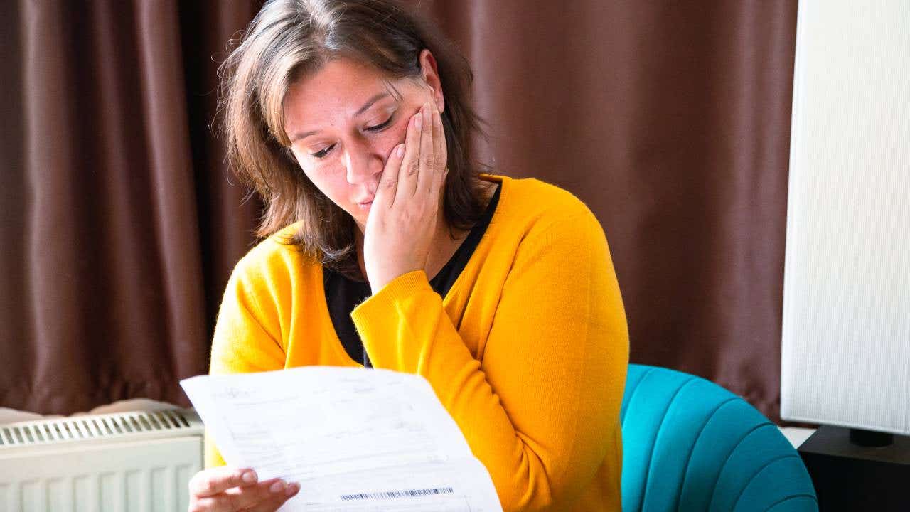 Worried woman checking bills at home