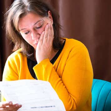 Worried woman checking bills at home
