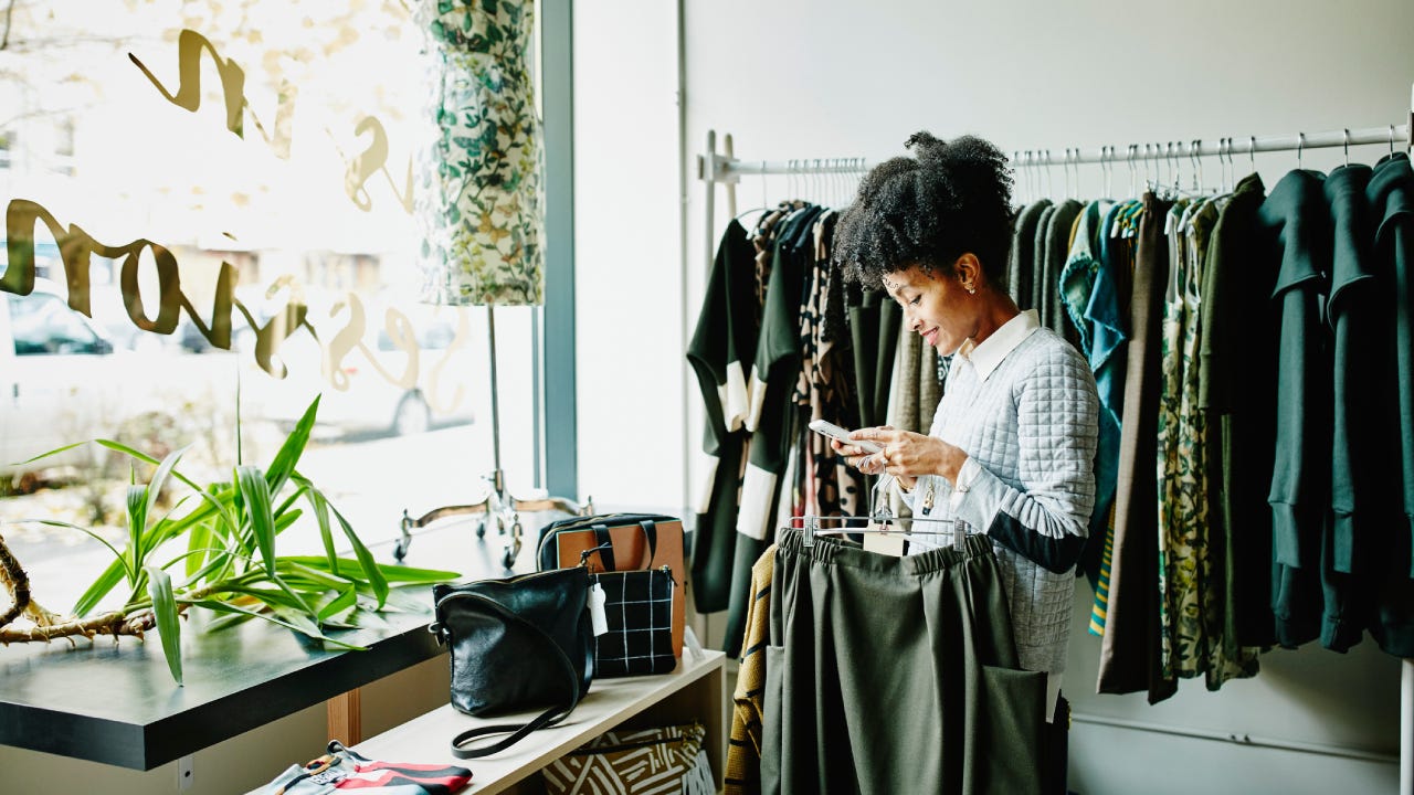 Woman checking smartphone while shopping