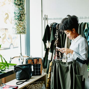 Woman checking smartphone while shopping