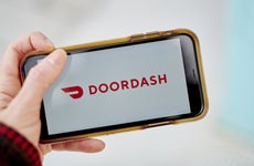 Picture of someone holding a phone with DoorDash app
