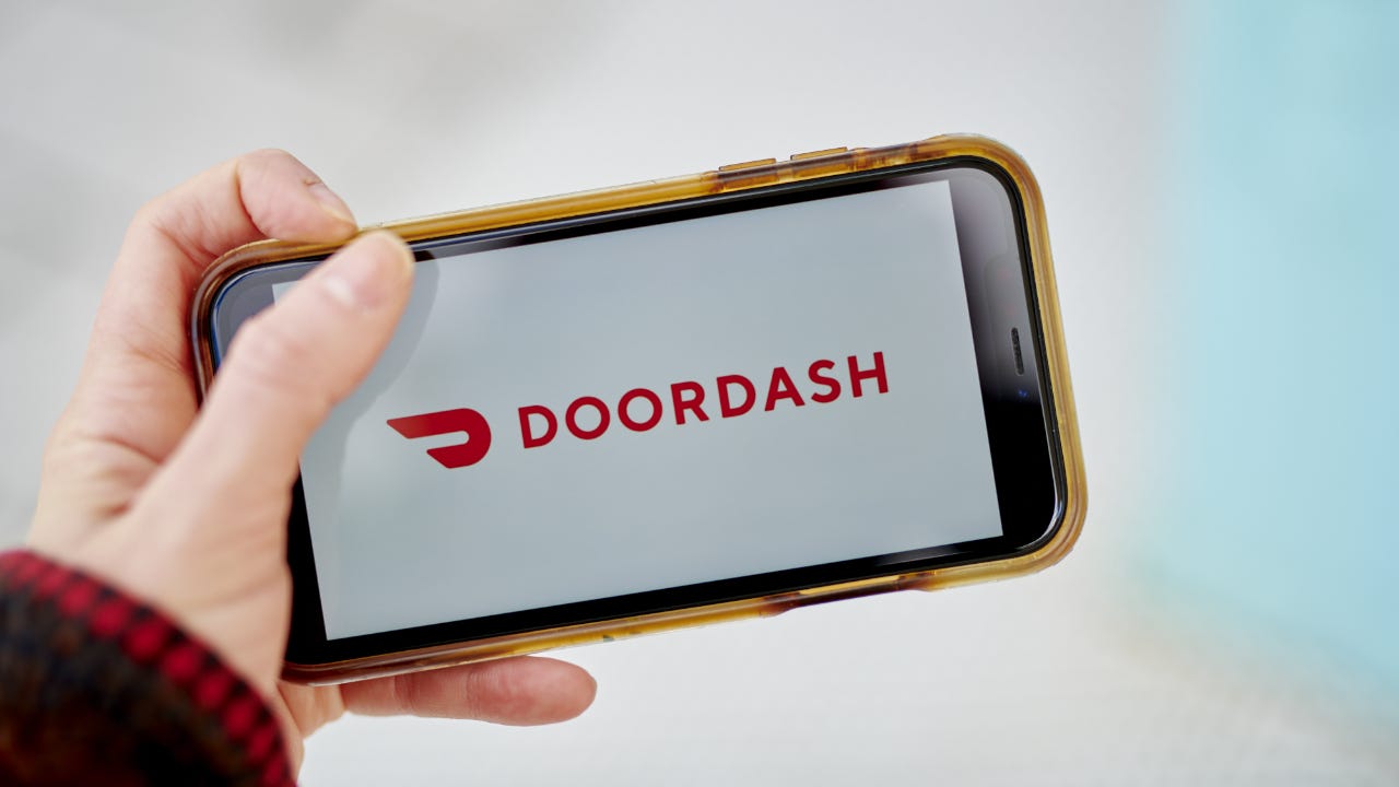 Picture of someone holding a phone with DoorDash app