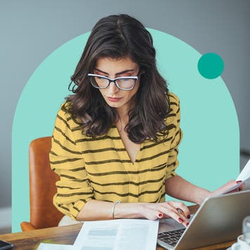 Woman looking at documents in front of the computer