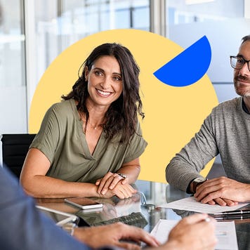 A man and woman discuss loan details with a bank advisor.