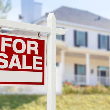 Home For Sale Real Estate Sign in Front of Beautiful New House.