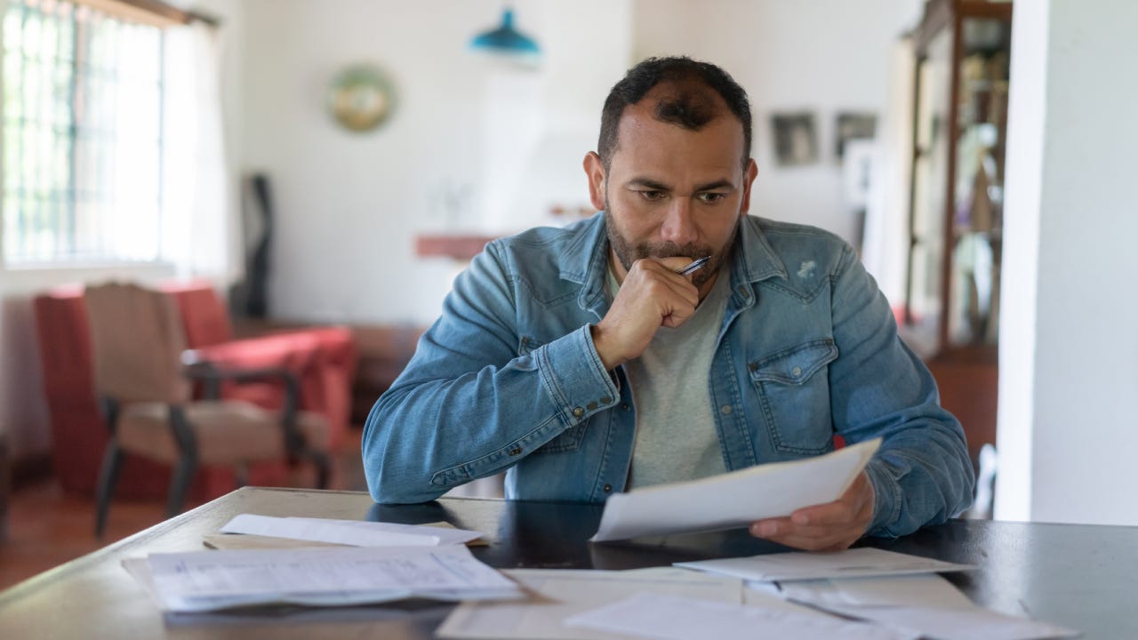 Low income man checking his home finances and looking worried