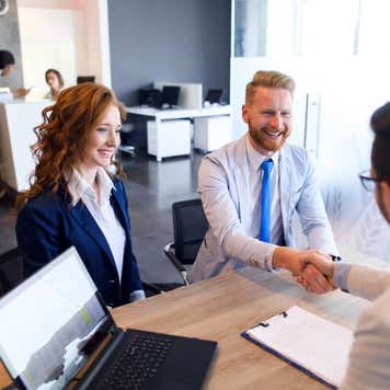 Image of young couple talking to loan officer. Male client and financial advisor are shaking hands.