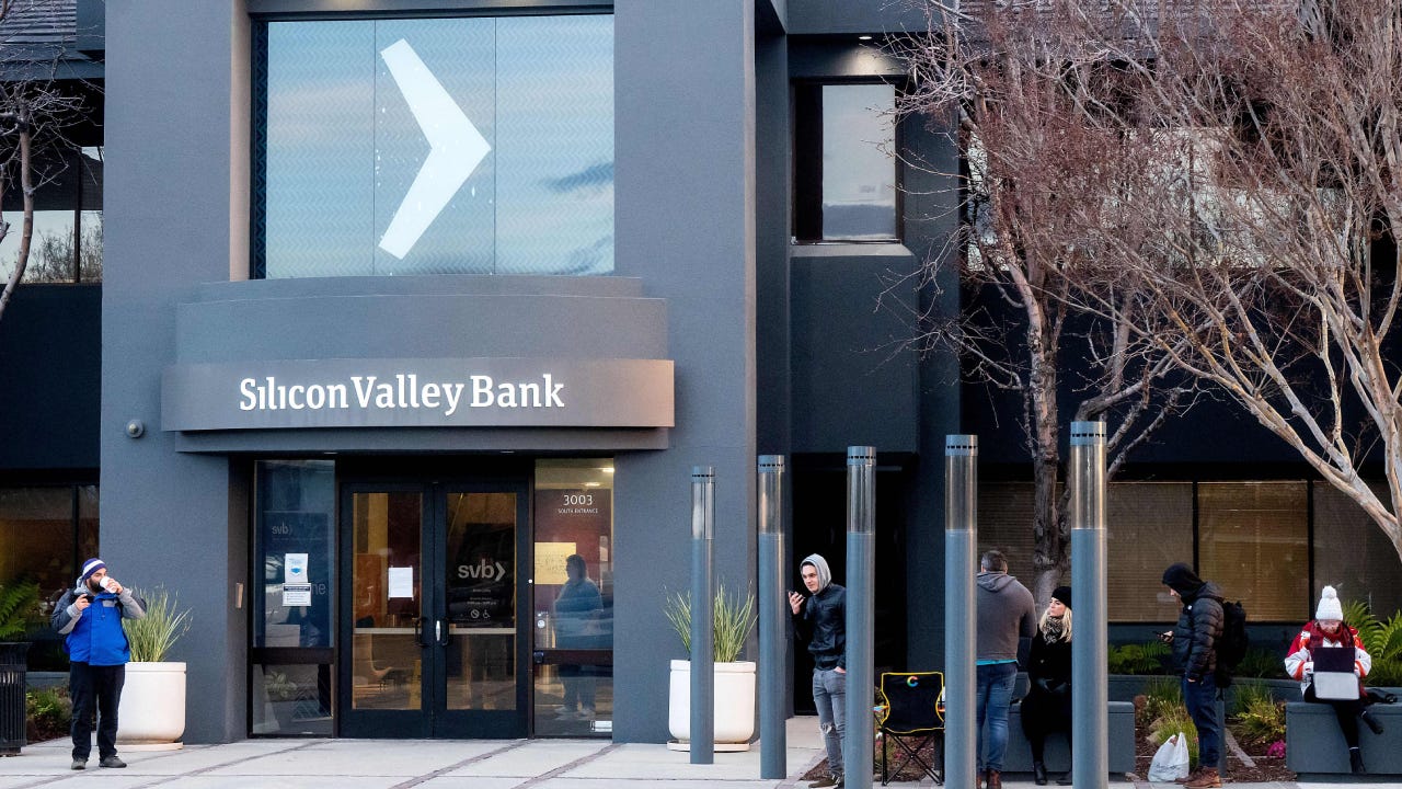 People waiting in the cold outside of a bank