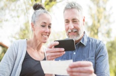 Elderly couple deposits check via mobile phone
