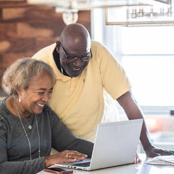 Senior couple using laptop in kitchen