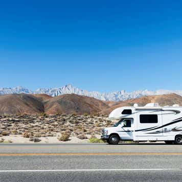 Camper in rolling Hills with Eastern Sierras in the Distance from Hwy 395