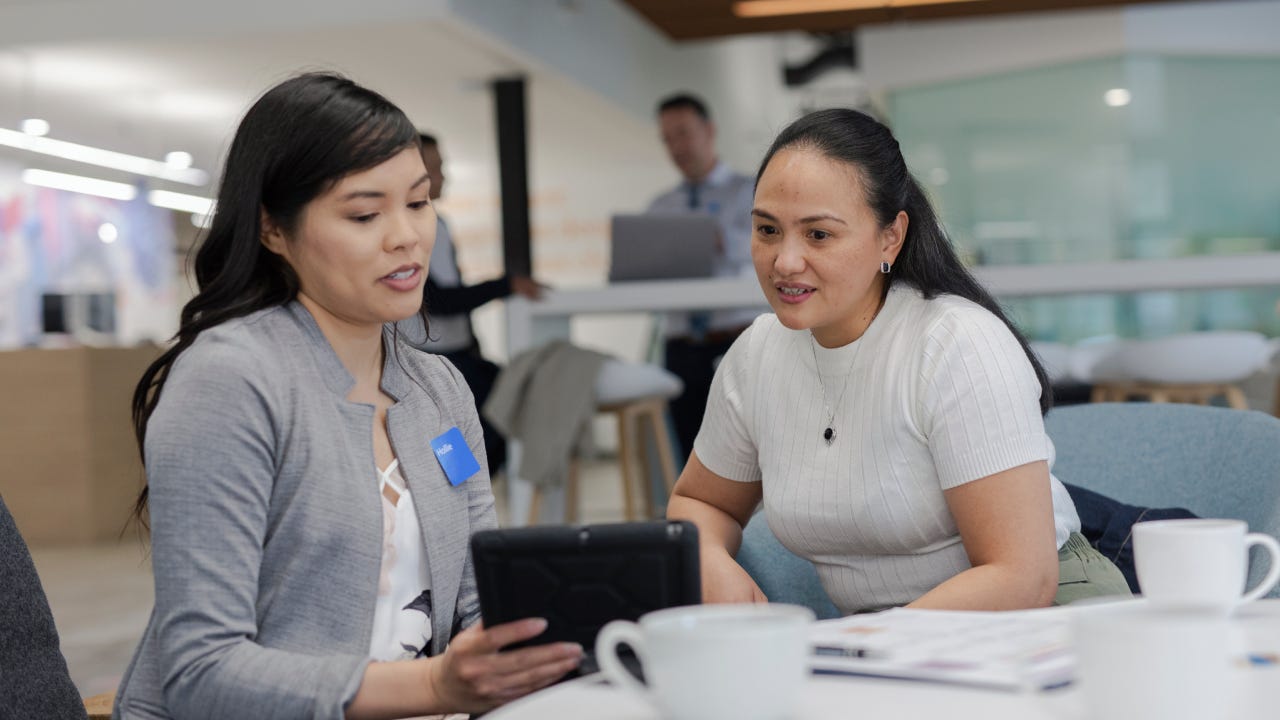 Two women discussing documentation in an office