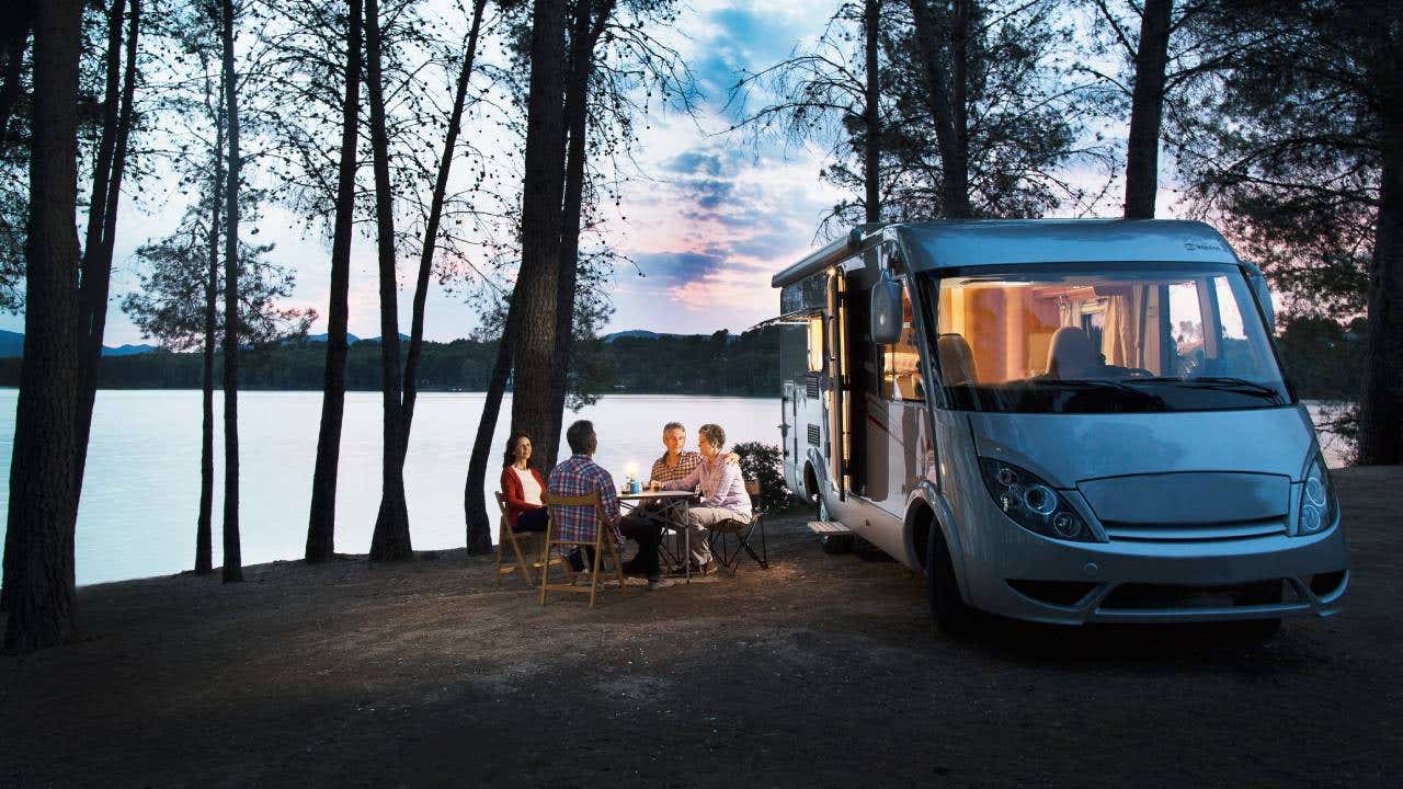 Friends sitting outside motorhome in the evening