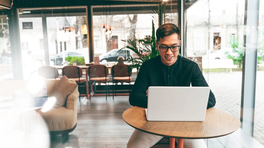 Young man working on laptop in cafe