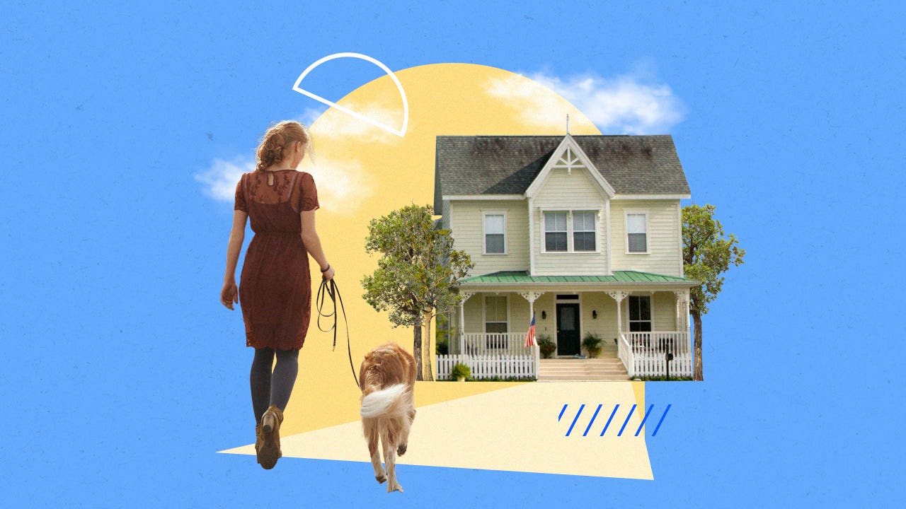 Woman walking her dog toward a house