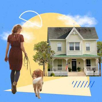 Woman walking her dog toward a house