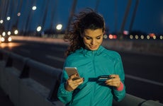 Athletic woman using credit card and mobile phone