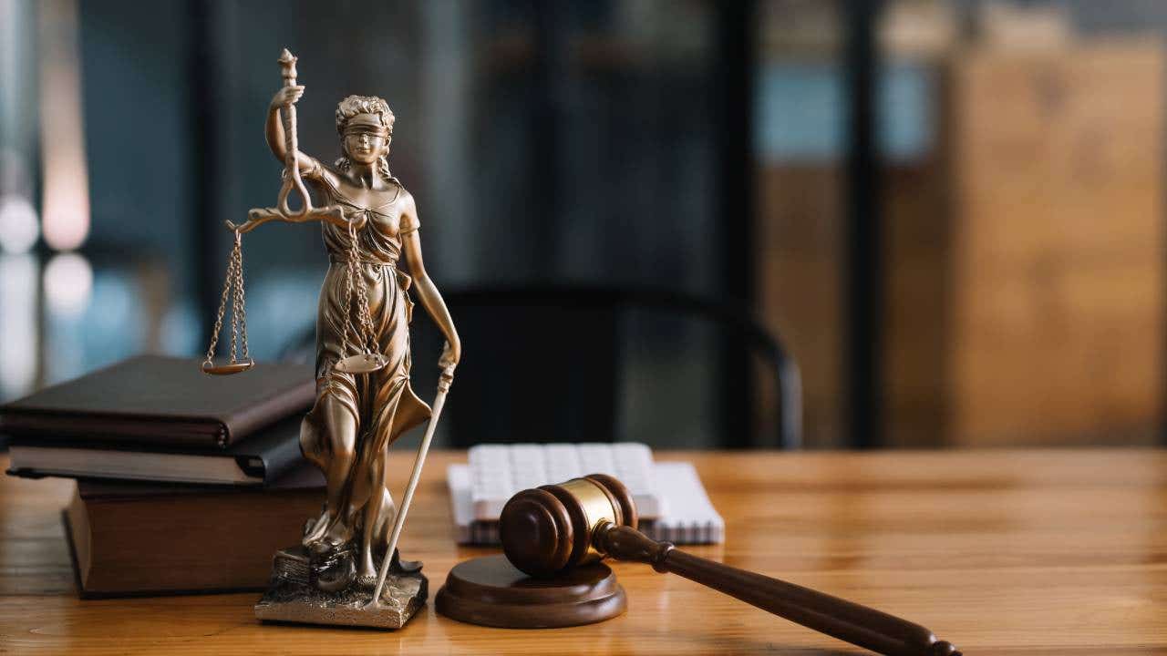 Statue of lady justice on desk of a judge or lawyer.