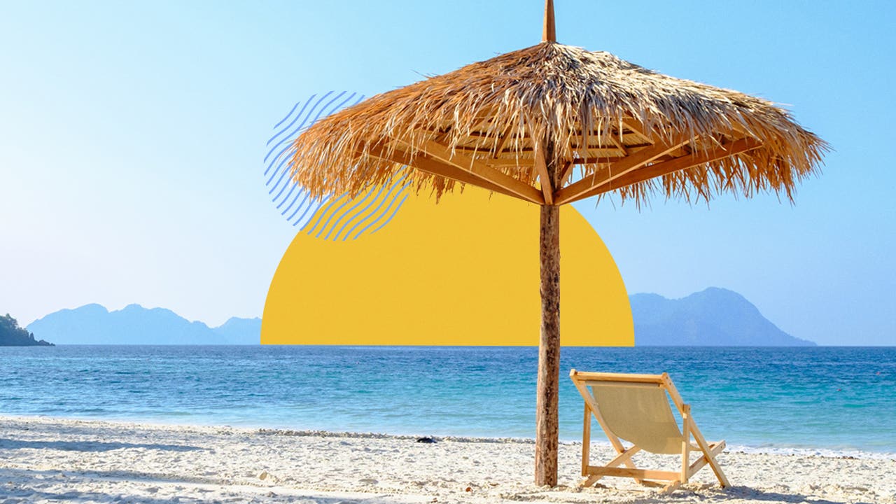 Scene of a beach with a woven grass umbrella over a nice beach chair in front of a clear, blue shoreline.