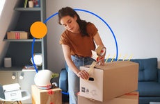 Woman using packing tape to seal boxes