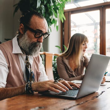 A couple of adults are working with laptops