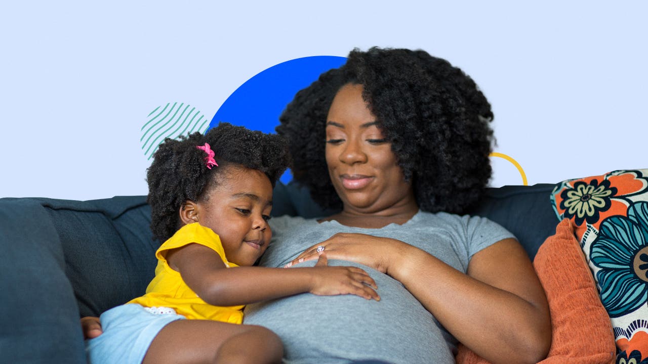 Pregnant black parent with black child feeling baby kick