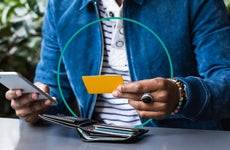 design element of a close up shot of a person holding a credit card and phone in their hands
