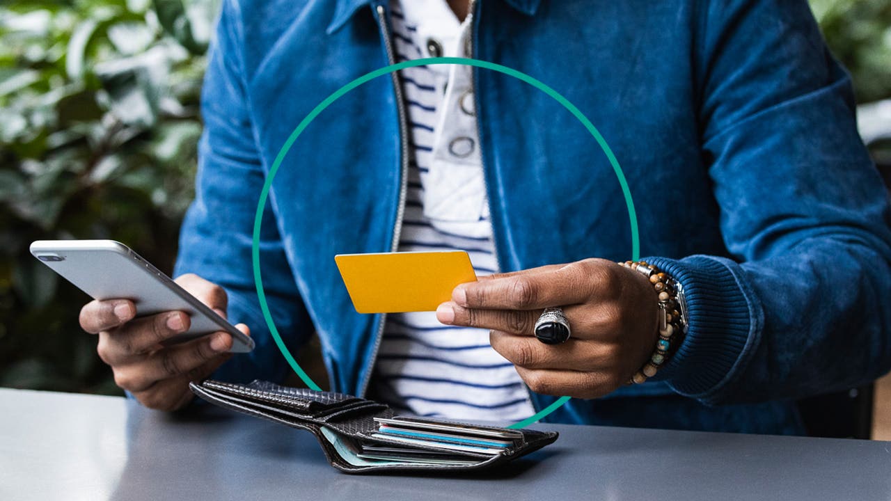 design element of a close up shot of a person holding a credit card and phone in their hands