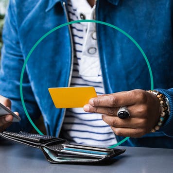 design element of a close up shot of a person holding a credit card and phone in their hands