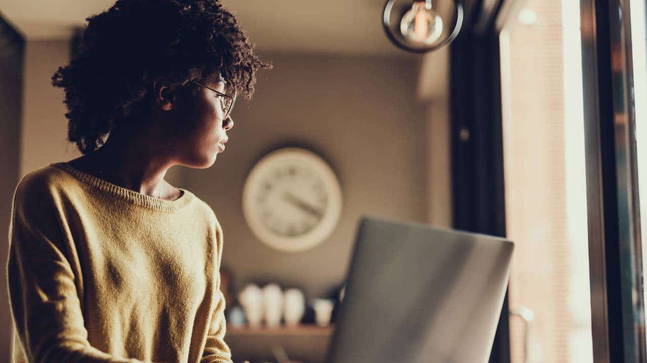 Young woman using laptop and sitting inside cafe