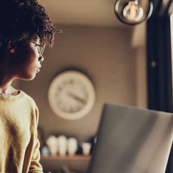 Young woman using laptop and sitting inside cafe