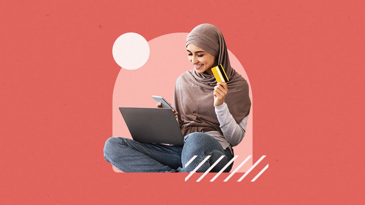 Woman on laptop with salmon-colored background