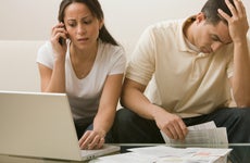 Distressed couple looking at documents and laptop