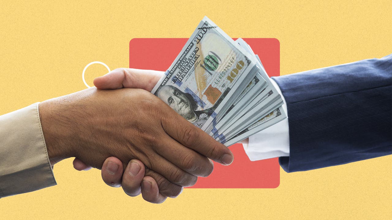 A hand shake, with money in one hand