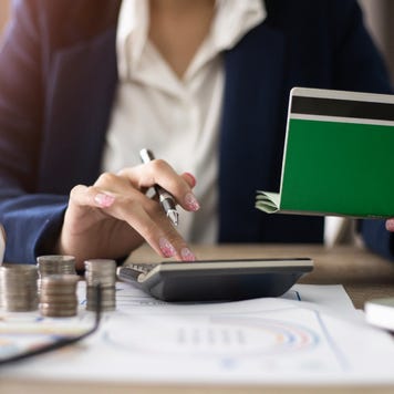 Women checking amount in bank account passbook with bank statement