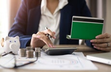 Women checking amount in bank account passbook with bank statement