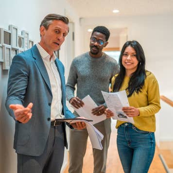 Male real estate agent with a young married couple.
