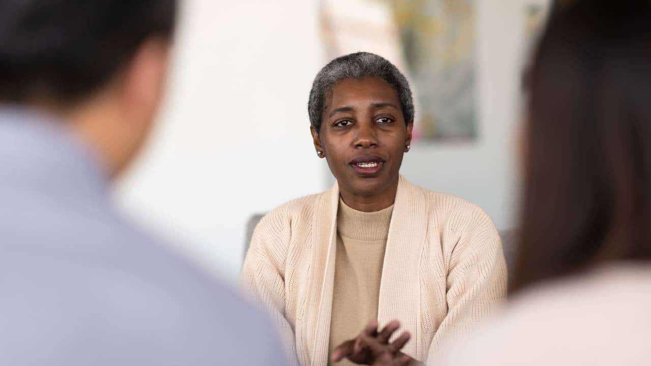 An elderly financial counselor talks to her two clients about their struggles and obstacles